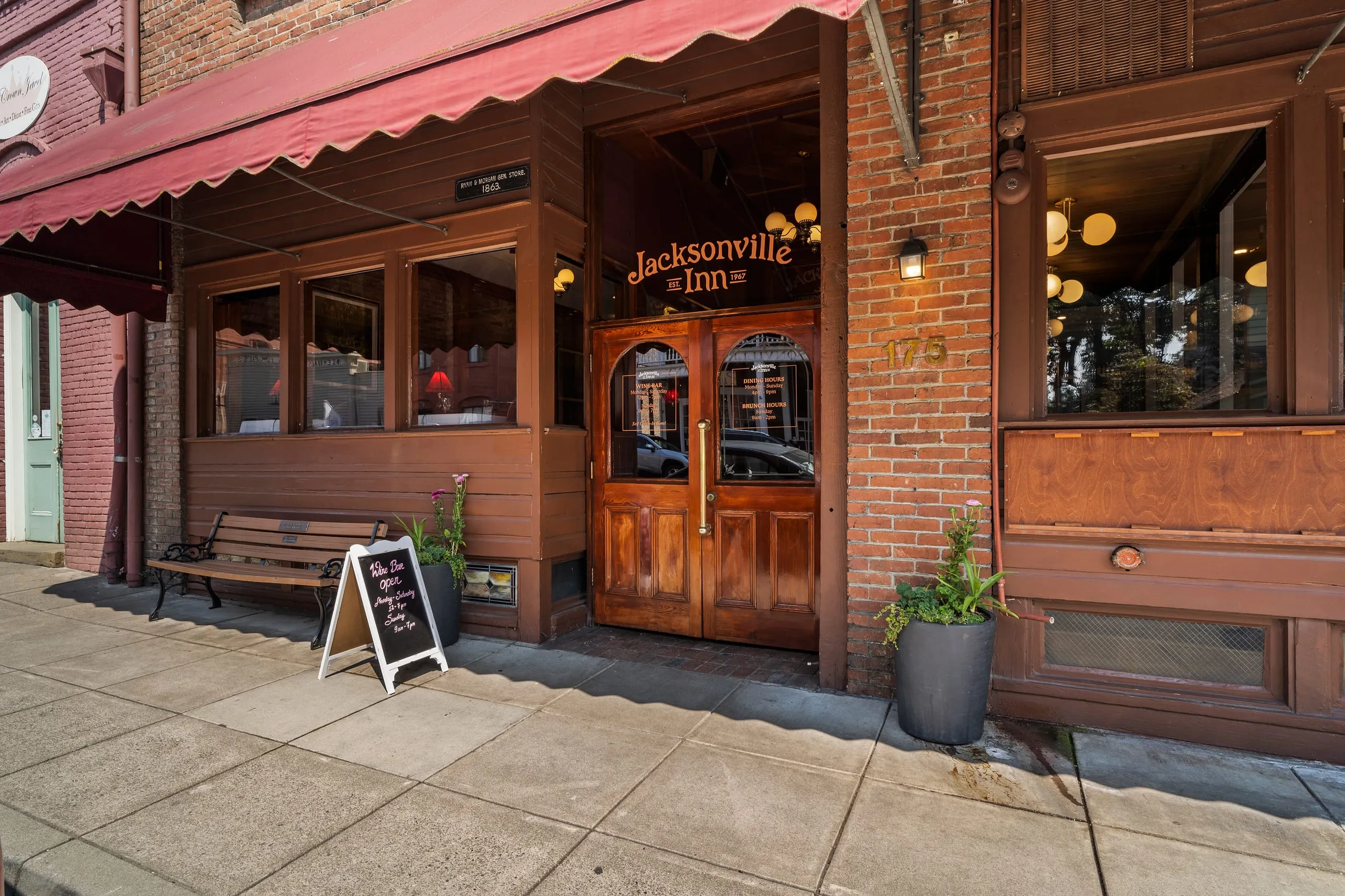 The Jacksonville Inn’s storefront on California Street: red brick, a red awning, and the gold-lettered front doors.
